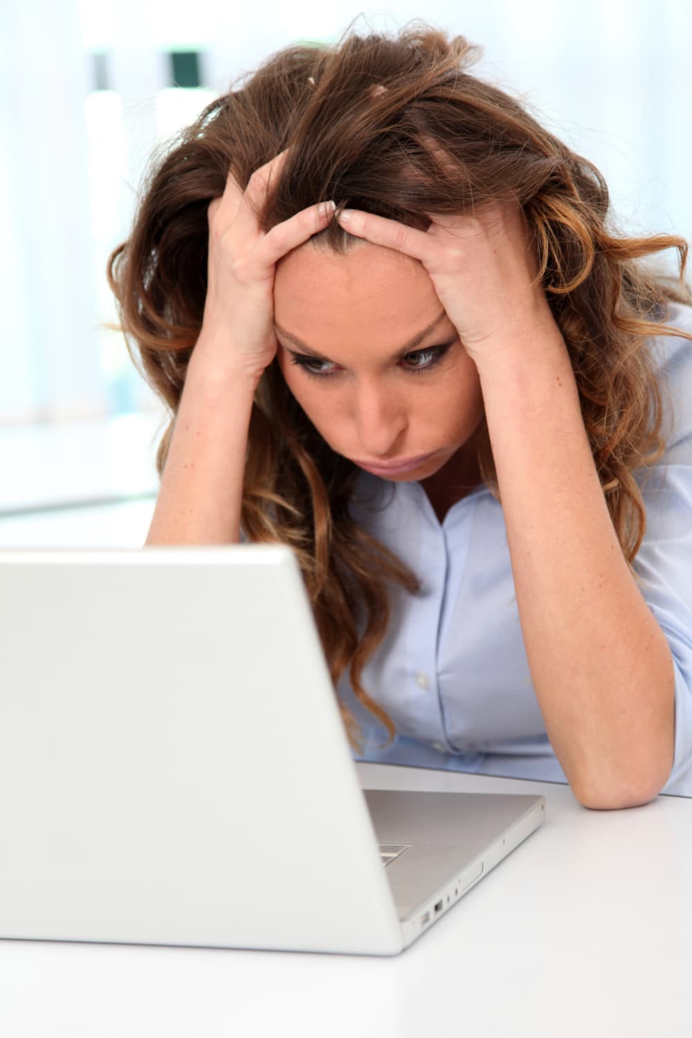 woman frustrated with website sitting at laptop