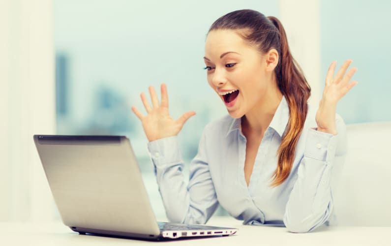 woman excited hands up with laptop