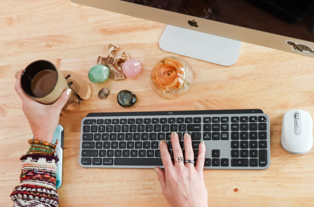 lisas hands on keyboard with cup of coffee