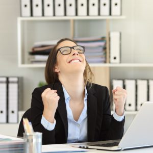 excited businesswoman celebrating success at office