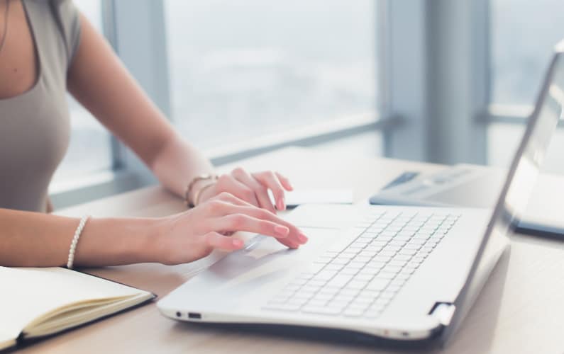 woman writing her blog post on laptop