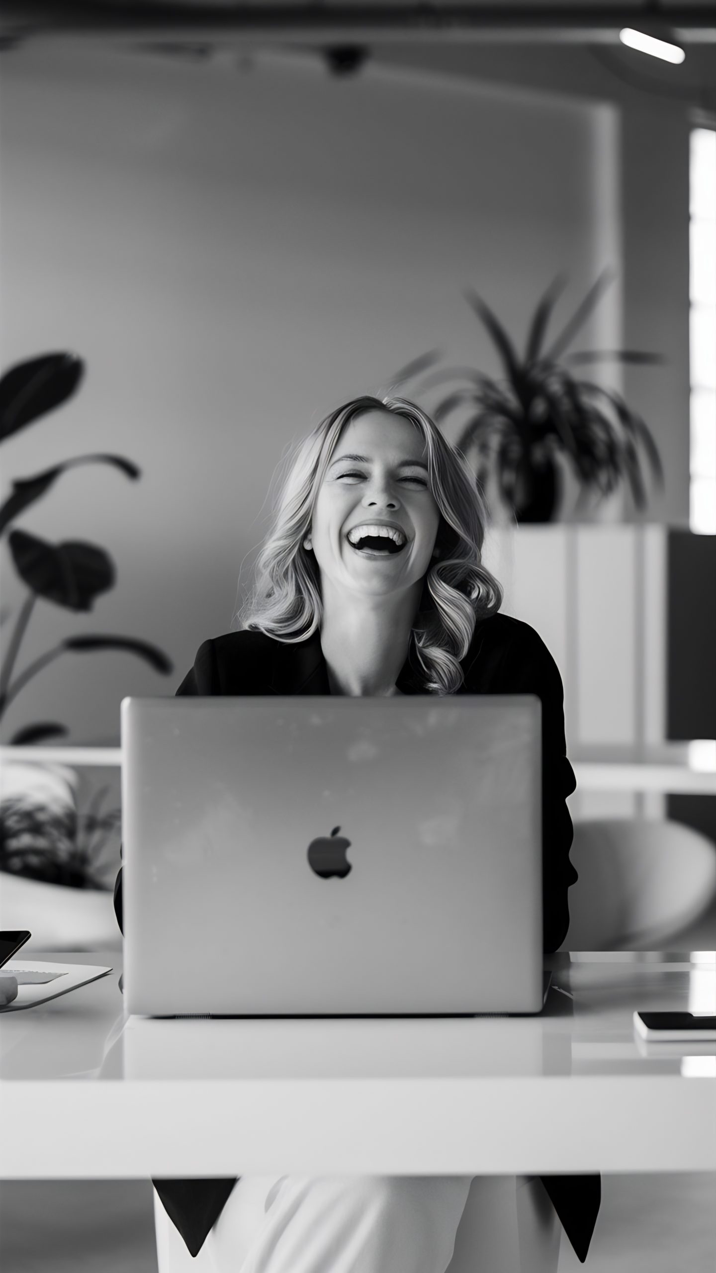 laughing woman with laptop office
