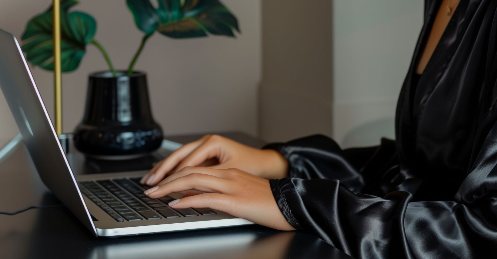 woman working on laptop with plant in background